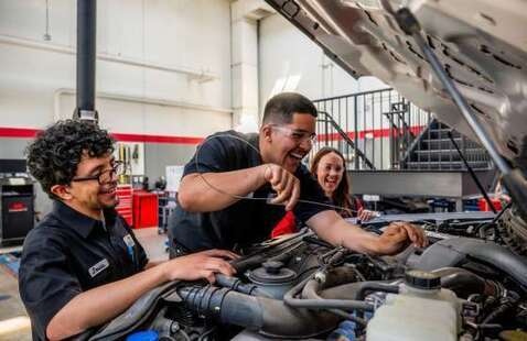 Students working under the hood of a car