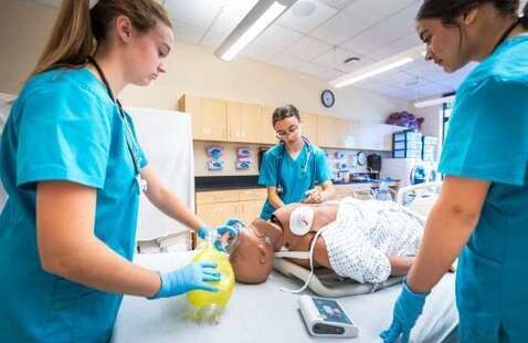 nurse aid students working on maniquin