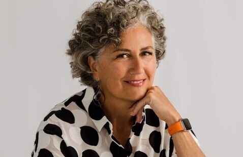 Headshot of Jean Thompson. White woman with short, curly brown hair mixed with grey. Wearing a white shirt with black polka dots. 