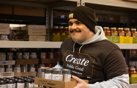 a male student carrying a box of donation goods working on MLK day of service