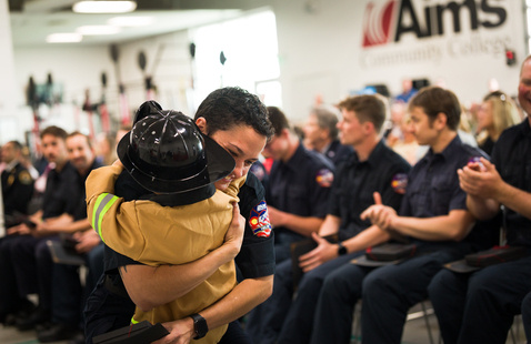 child hugging parent at fire academy graduation