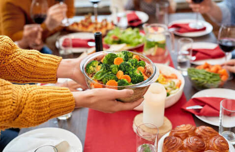Bowl of vegetables being passed at a dinner gathering