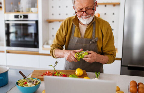Male older adult cooking with vegetables 