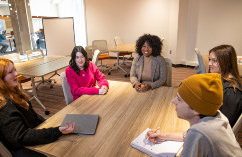 A few students in a classroom looking at eachother with an idea