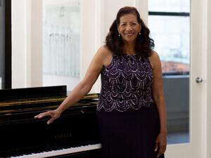 Photograph of Fredericka King standing in front of a grand piano.