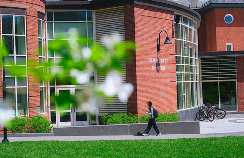 Student walks by Community Center in spring.