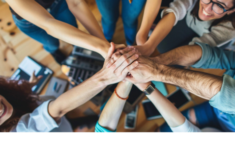 Group of people holding out their hands together