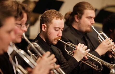 Students playing trumpets during on-stage performance