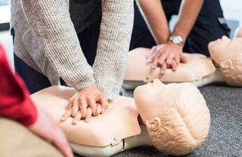 Two people performing CPR on manikins