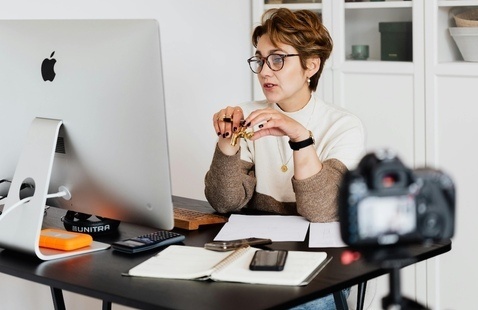 Professor at her computer with a camera on her to record the lesson