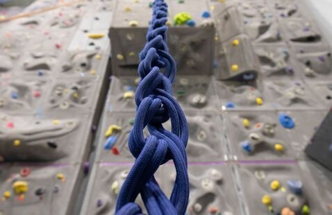 Rope going up an indoor climbing wall.