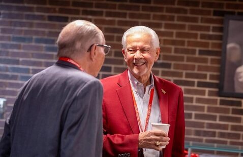 Two alumni talk during alumni event on campus