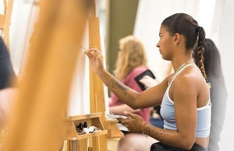 A student paints on an easel during art class
