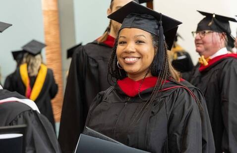 Smiling graduating student gathered with graduates in Columbia