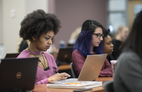Student typing on laptop