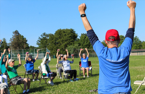 Doc and attendees stretching out on a field