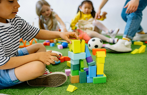 Boy in White and Black Striped Shirt Playing Wooden Blocks