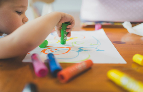 A Child Playing with Coloring Pens