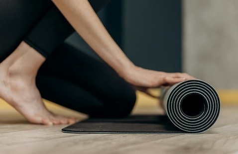 Person rolling up a yoga mat