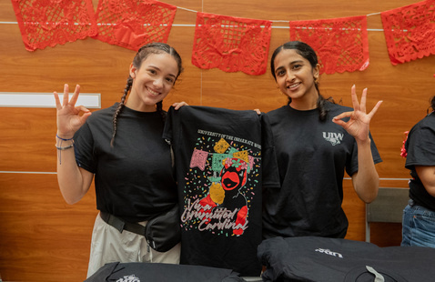 Two students holding up a Cardinal Fiesta T-shirt