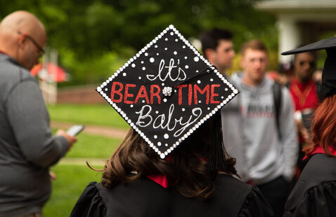 Student shows off decorated graduation cap that reads It Bear Time Baby