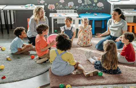 children sitting on the floor listening to the librarian