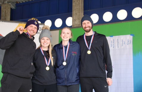 Group of four people wearing gold medals