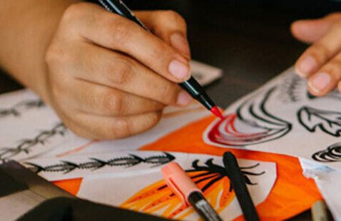 hand with colored marker coloring a drawing