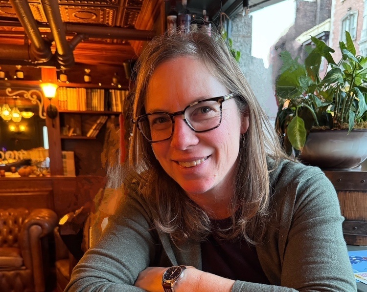 Meika Loe smiling at the camera, arms crossed in front of her. 