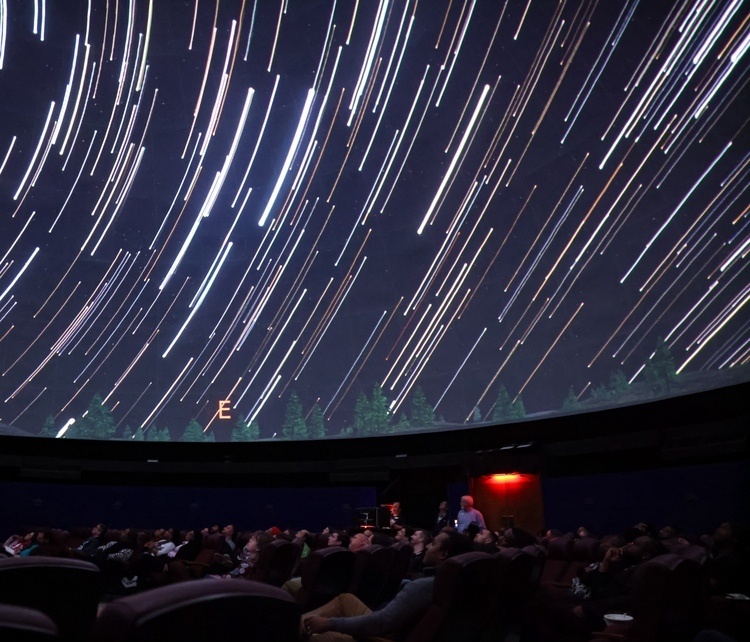 The path of stars across a planetarium dome.