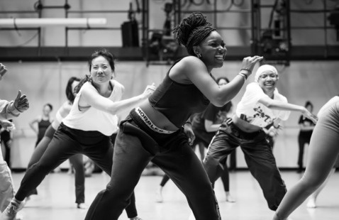 Black and white of students joyfully dancing.
