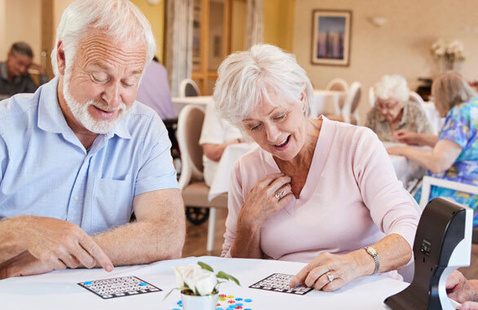 Two older adults playing bingo