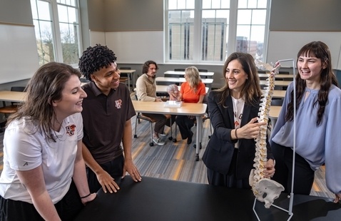 students together looking at a model spine