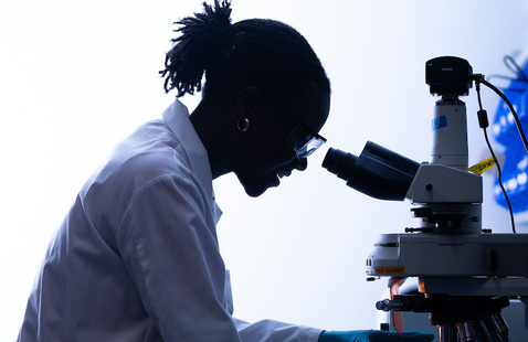 A student looking into a microscope