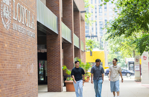 Three students walking outside of the Arrupe College building