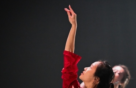 profile of a dancer raising one arm.