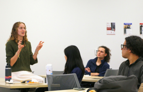 A woman talking to a group of people. 