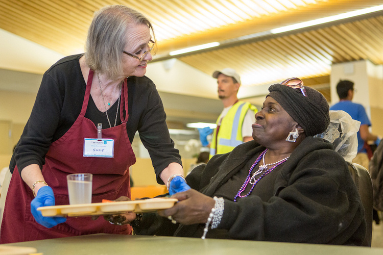 A woman being served at a soup kitchen.
