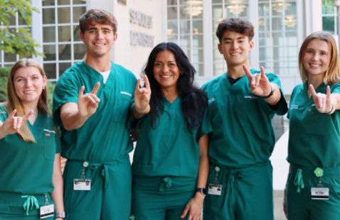 5 dental students standing in front of school posing for a photo with hands out in a "blaze" symbol