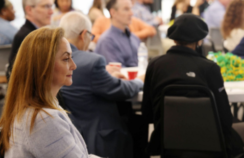 UAB SOD faculty member sitting among other faculty and staff in conference room