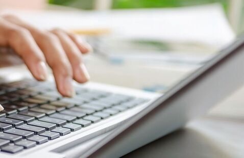 Person at a laptop typing. 