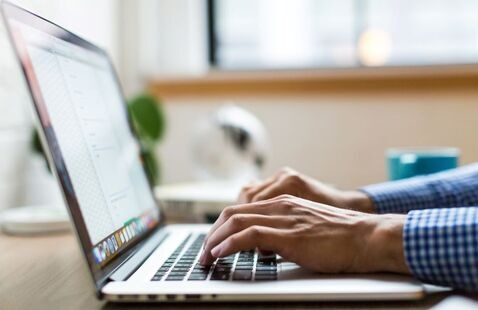 A person typing on a laptop
