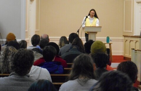 a student reading to an audience