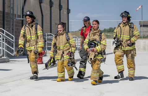 Photo of 2025 Xplore Academy students in fire uniforms.