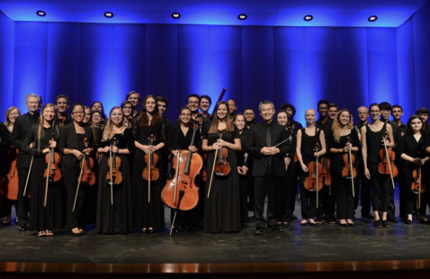 UNF Orchestra students standing with instruments