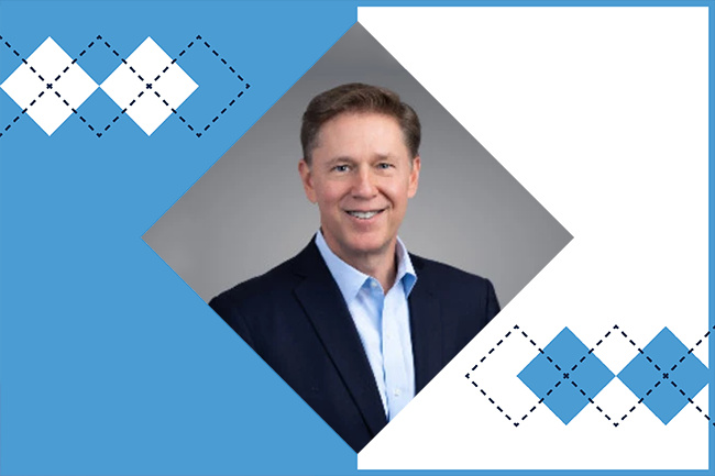 A photo of Kevin J. Martin cropped into a Carolina graphic featuring Carolina blue and argyle.