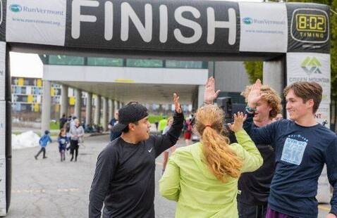 Finishers from last year's 5k high five at the finish line of the Find Your Route race.