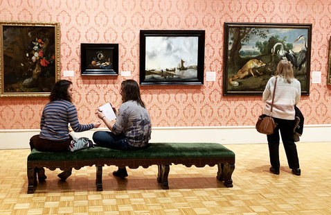People sitting in the galleries, looking at artwork