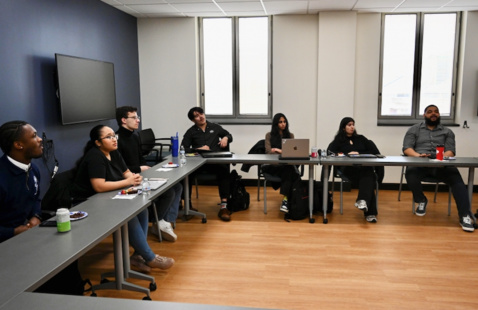 Seven students sit inside the Kearns Center classroom.