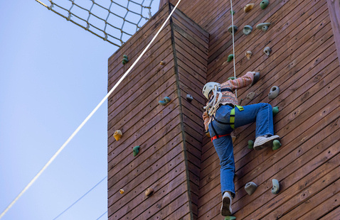 A person climbs on Outdoor Pursuit's outdoor climbing wall. 